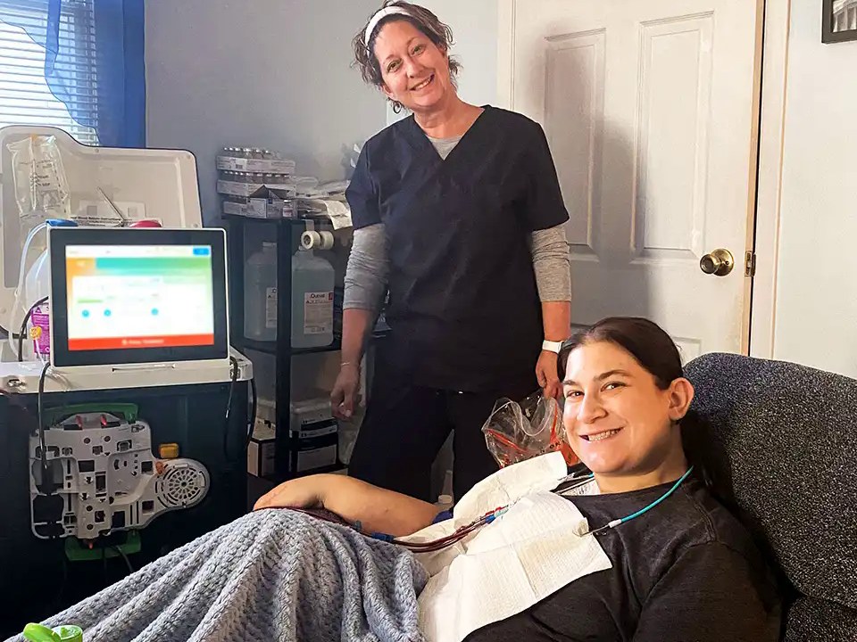 A Spectrum Dialysis nurse training a patient on his home hemodialysis machine at his kitchen table
